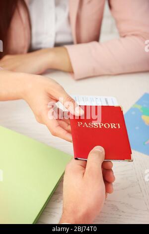 Reisebüro, das dem Kunden im Büro des Reiseunternehmens Reisepass und Ticket ausgibt Stockfoto