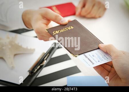 Reisebüro, das dem Kunden im Büro des Reiseunternehmens Reisepass und Ticket ausgibt Stockfoto