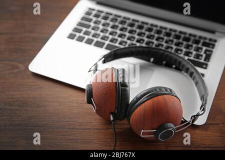 Kopfhörer und Laptop auf Holztisch Nahaufnahme Stockfoto