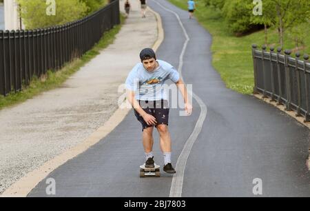 St. Louis, Usa. April 2020. Ein Skate Boarder beschleunigt am Dienstag, den 28. April 2020, den Hügel hinunter, vorbei am Zoo von Saint Louis im Forest Park in St. Louis. Foto von Bill Greenblatt/UPI Quelle: UPI/Alamy Live News Stockfoto