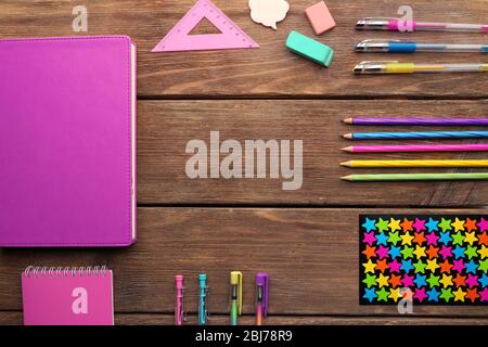 Schulset mit Notizbüchern, Buntstiften und Bleistiften auf Holzhintergrund Stockfoto