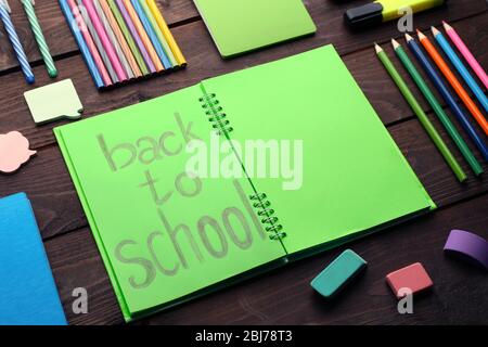 Schule mit Rücken zur Schule Inschrift in Notebook und Briefpapier auf hölzernen Hintergrund festlegen Stockfoto