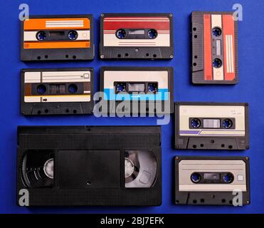 Satz alter Audio- und Videokassetten auf blauem Hintergrund Stockfoto