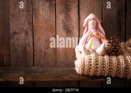 Spielzeug Hase mit Wollschal auf Holzhintergrund Stockfoto