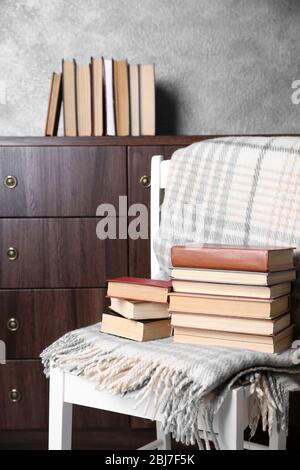 Stapel Bücher mit warmen Plaid auf dem Stuhl Stockfoto