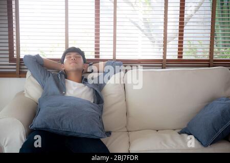 Portrait junger, gutaussehender asiate man schläft sich mit gemütlichem Sofa zu Hause, asien männlich am Wochenende ausruhen und schlafen mit müden und faulen auf der Couch in V Stockfoto