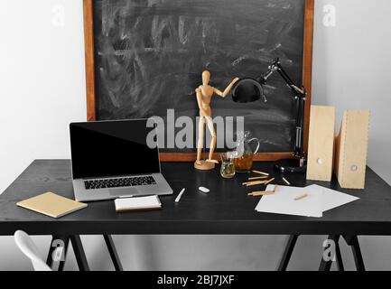 Desktop mit Notebook und anderen Elementen auf Tafel Hintergrund Stockfoto