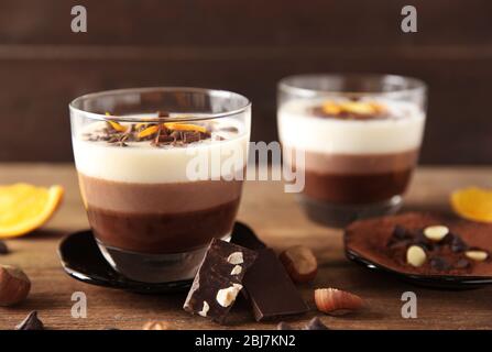 Mehrschichtige Desserts mit Dekoration auf Holztisch Stockfoto