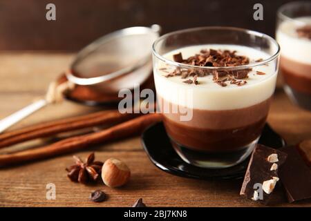 Mehrschichtige Desserts mit Dekoration auf Holztisch Stockfoto