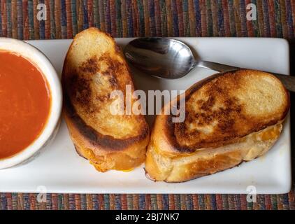 Gegrillte Käsesandwiches und Tomatensuppe; leichte Komfortkost während einer Pandemie Stockfoto