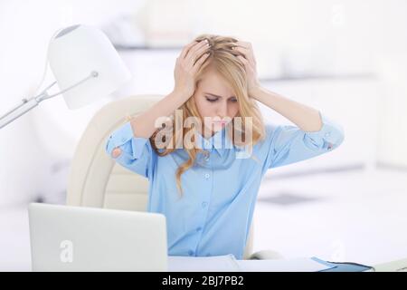 Müde Frau am Laptop im Büro Stockfoto