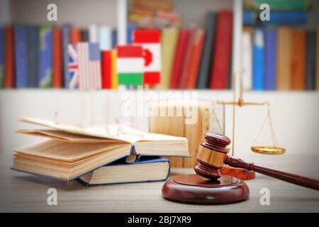 Gavel mit Gerechtigkeitswaagen und Büchern auf Holztisch Stockfoto