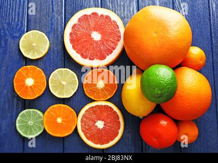 Saftige Komposition aus geschnittenen Zitrusfrüchten auf blauem Holzhintergrund Stockfoto