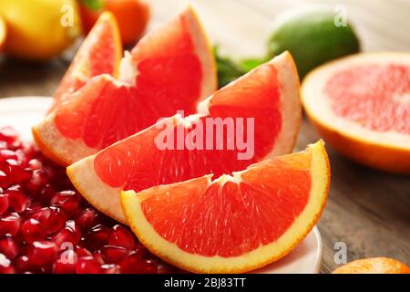 Saftige Grapefruit und Granatapfel auf einem Teller, aus nächster Nähe Stockfoto