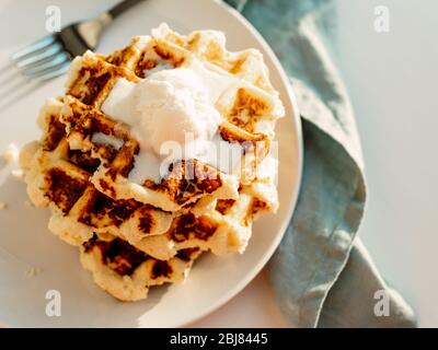 Ricotta Käse schabt für Keto Ernährung. Stapel von Ricotta und Zitrone belgischen Waffeln mit Eislöffel dekoriert. Platz für Text kopieren. Natürlicher Sonnenuntergang oder Sonnenaufgang Tageslicht. Draufsicht oder flaches Lay Stockfoto