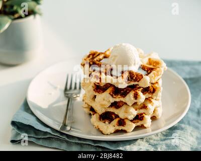 Ricotta Käse schabt für Keto Ernährung. Stapel von Ricotta und Zitrone belgischen Waffeln mit Eislöffel dekoriert. Platz für Text oder Design kopieren. Natürliches Tageslicht bei Sonnenuntergang Stockfoto