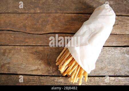 Brotsticks grissini mit Sesamsamen in Handpackung auf Holzhintergrund Stockfoto