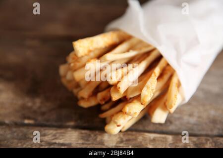 Brotsticks grissini mit Sesamsamen in Handpackung auf Holzhintergrund Stockfoto