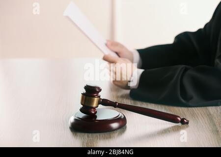 Richter Lesestoff mit dem Gavel am Holztisch im Gerichtssaal Stockfoto