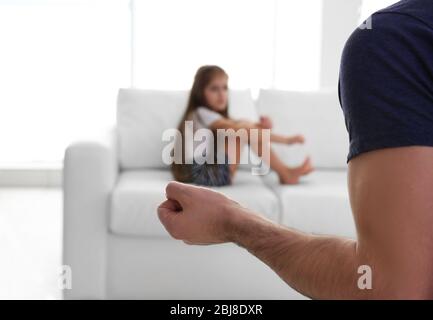 Die Faust des Vaters als Strafe und seine junge Tochter auf der Couch Stockfoto