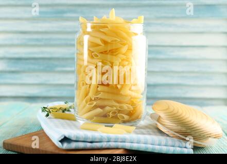 Rohe Pasta im Glas auf Holzhintergrund Stockfoto