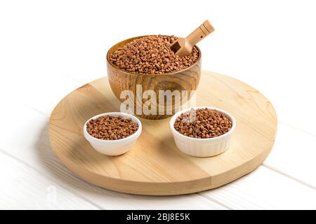 Braune Buchweizenkörner in Holzschale auf isoliertem weißem Hintergrund gesunde Ernährung, Superfood-Konzept. Stockfoto