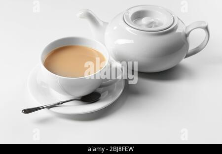 Milchtee mit Teekanne auf weißem Hintergrund Stockfoto