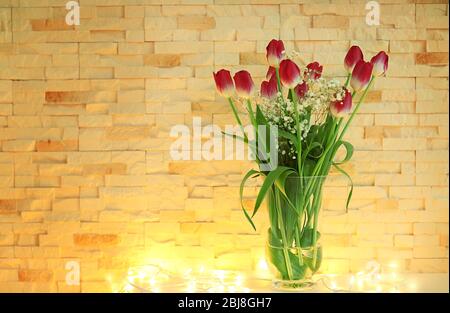 Tulpen auf dem Tisch vor Backstein Wand Hintergrund Stockfoto