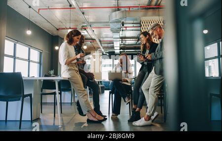 Mitarbeiter treffen sich in einem modernen Büro. Gruppe von multiethnischen Geschäftsleuten, die ein Meeting im Startup-Büro abhalten. Stockfoto