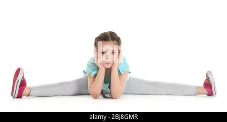 Kleines nettes Mädchen sitzt in den Spalten, isoliert auf weiß Stockfoto