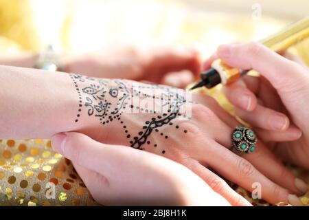 Malen Henna Tattoo auf weibliche Hand Stockfoto