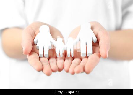 Weibliche Hände halten Familienfigur, Nahaufnahme Stockfoto