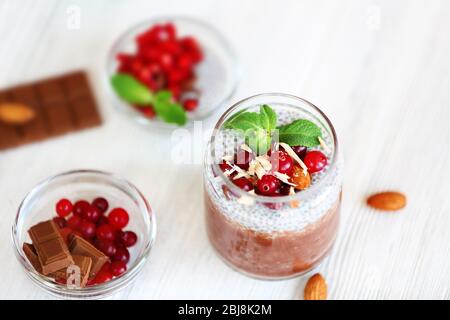 Schokoladenchia-Samenpudding mit Cranberry und zerdrückten Mandeln auf hellem Holztisch Stockfoto