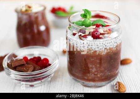 Schokoladenchia-Samenpudding mit Cranberry und zerdrückten Mandeln auf hellem Holztisch Stockfoto