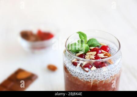 Schokoladenchia-Samenpudding mit Cranberry und zerdrückten Mandeln auf Holztisch Stockfoto