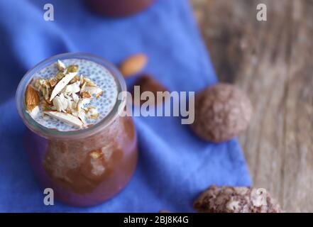 Schokoladenchia-Samenpudding mit zerdrückten Mandeln auf Holztisch Stockfoto