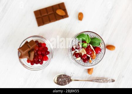 Schokoladenchia-Samenpudding mit Cranberry und zerdrückten Mandeln auf Holztisch Stockfoto