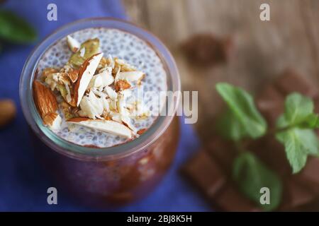 Schokoladenchia-Samenpudding mit zerdrückten Mandeln auf Holztisch Stockfoto