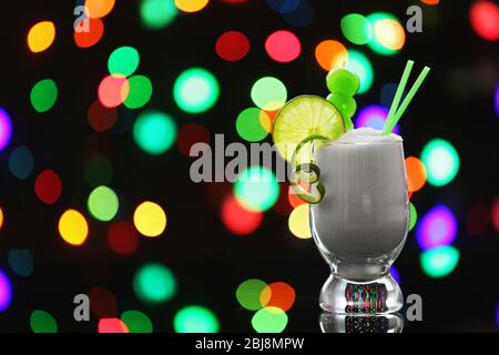 Tumbler Glas mit Granulatzucker auf dunklem Bokeh Hintergrund Stockfoto