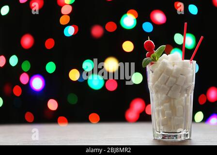 Highball Glas mit Klumpenzucker auf dunklem Bokeh Hintergrund Stockfoto