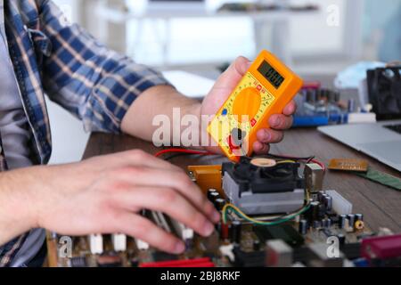 Männliche Hände prüfen elektronische Hardware im Service-Center Stockfoto