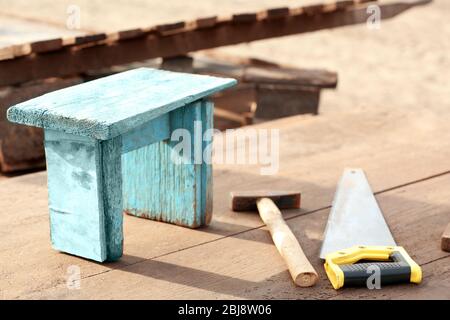 Kleiner Holzhocker, Hammer und Säge. Stockfoto