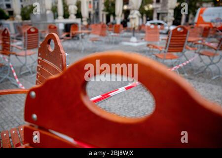Berlin, Deutschland. April 2020. Stühle und Tische eines mit Klebeband verschlossenen Restaurantbetriebs befinden sich auf dem Gendarmenmarkt. Quelle: Christoph Soeder/dpa/Alamy Live News Stockfoto