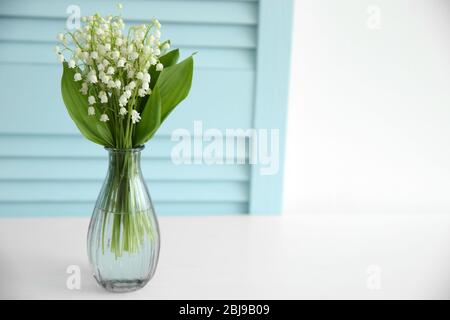 Blumenstrauß der Lilien des Tals in Vase auf hellem Hintergrund Stockfoto