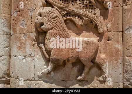 Eine aus Stein geschnitzte Löwenfigur neben einem Eingang im ersten Innenhof des Ishak Pasa Palace in Dogubayazit in der Türkei. Stockfoto