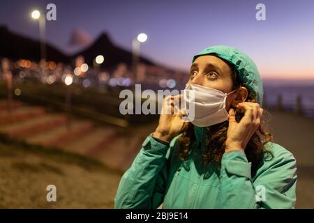 Kaukasische Frau, die eine Schutzmaske gegen Coronavirus aufsetzt Stockfoto