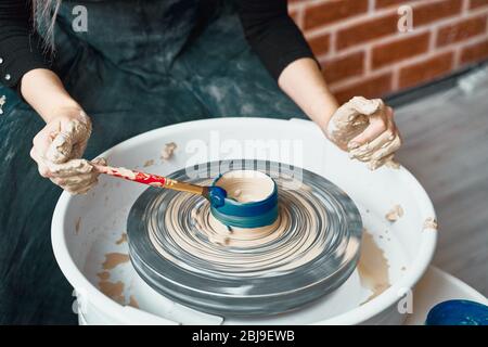 Unerkennbare Frau Herstellung Keramik Keramik auf Rad, Farben blau. Konzept für Frau in freiberuflicher, geschäftlicher. Handwerkliches Produkt. Verdienen Sie mehr Geld, Seite Stockfoto