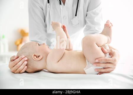 Doktor, der Übungen mit Baby macht Stockfoto