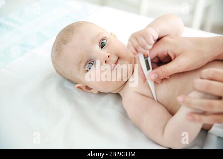 Arzt, der die Temperatur des Babys nimmt, Nahaufnahme Stockfoto
