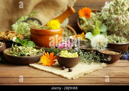 Kräuterauswahl in Kräutermedizin in Schalen auf Holztisch verwendet Stockfoto